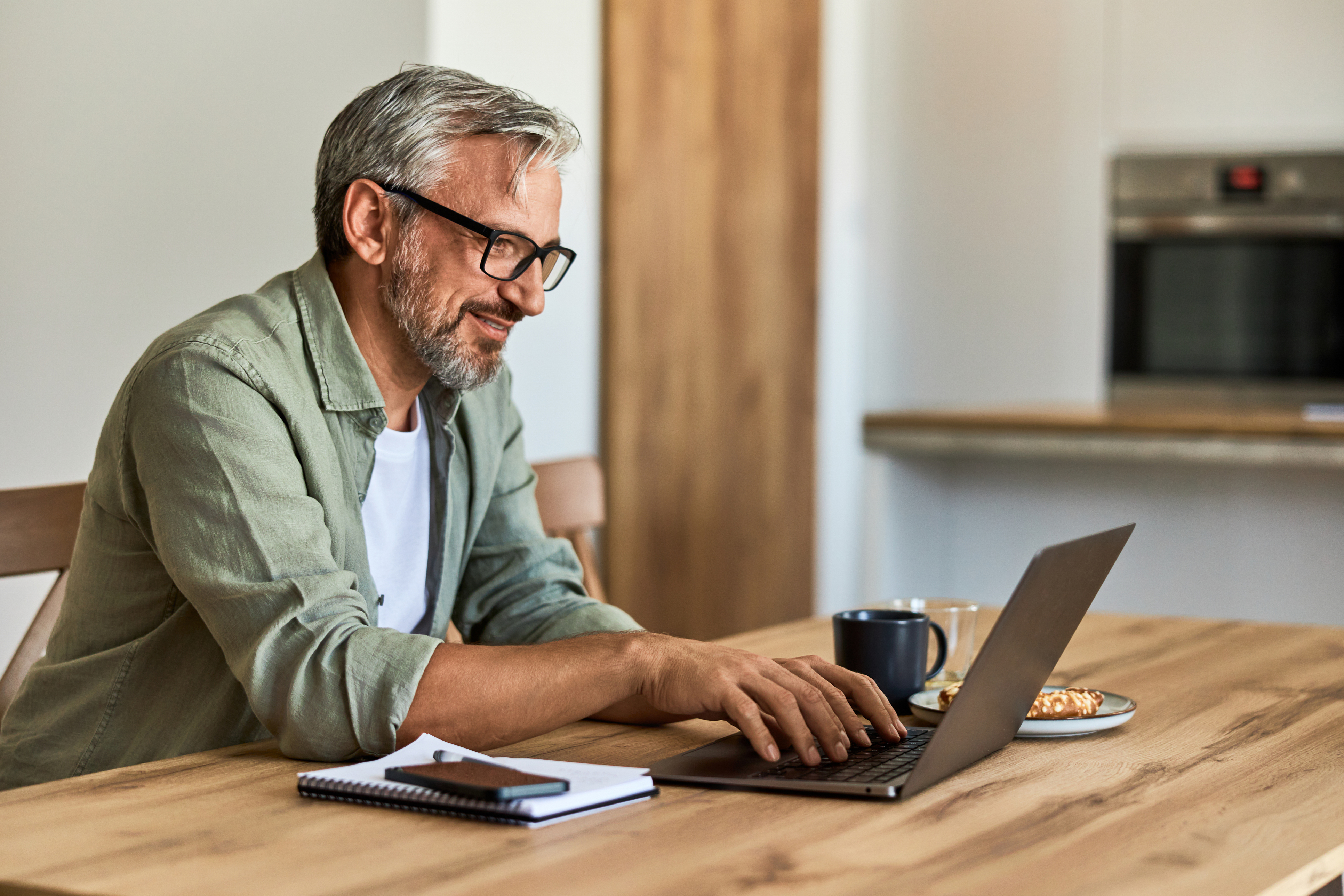 Man typing on laptop in office smiling