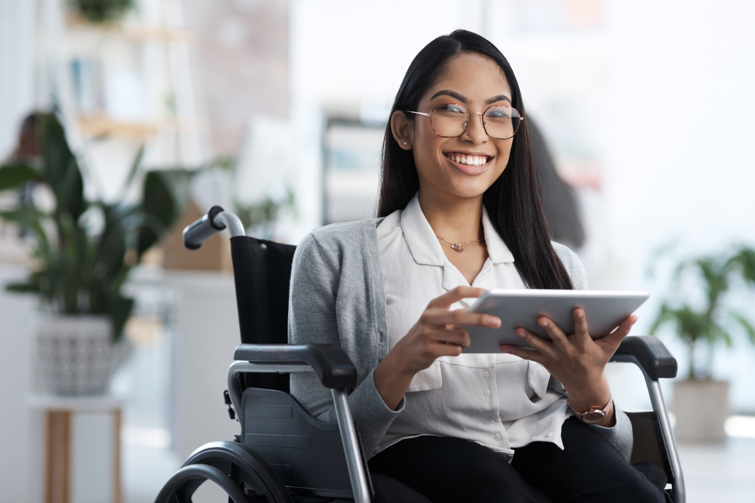 Woman in wheelchair working in office.