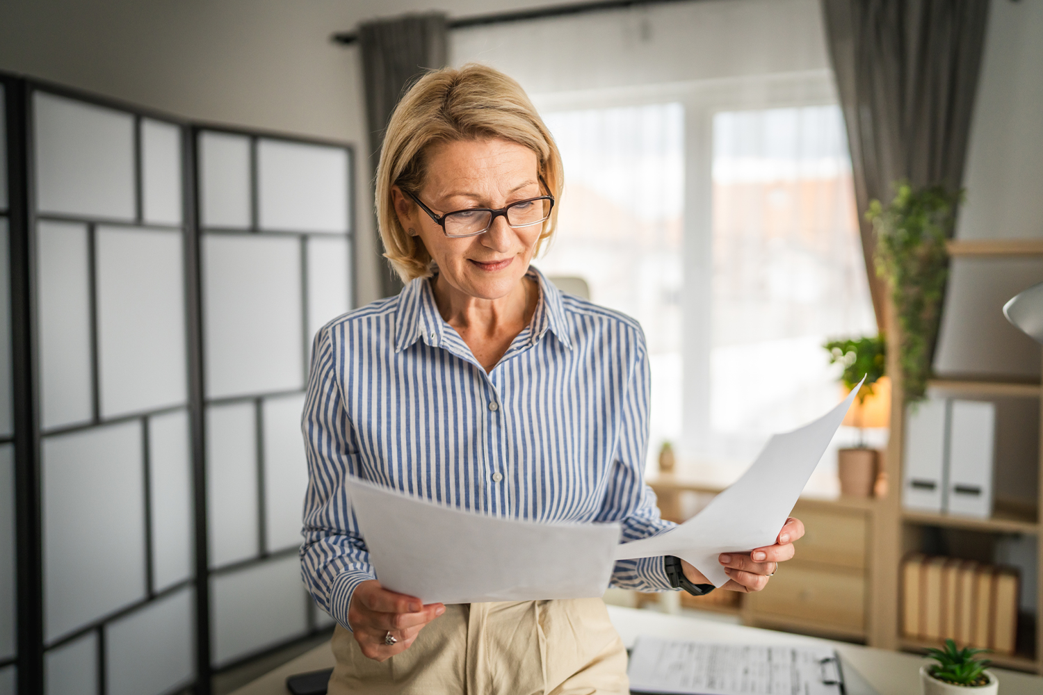 Woman reviewing papers in office.