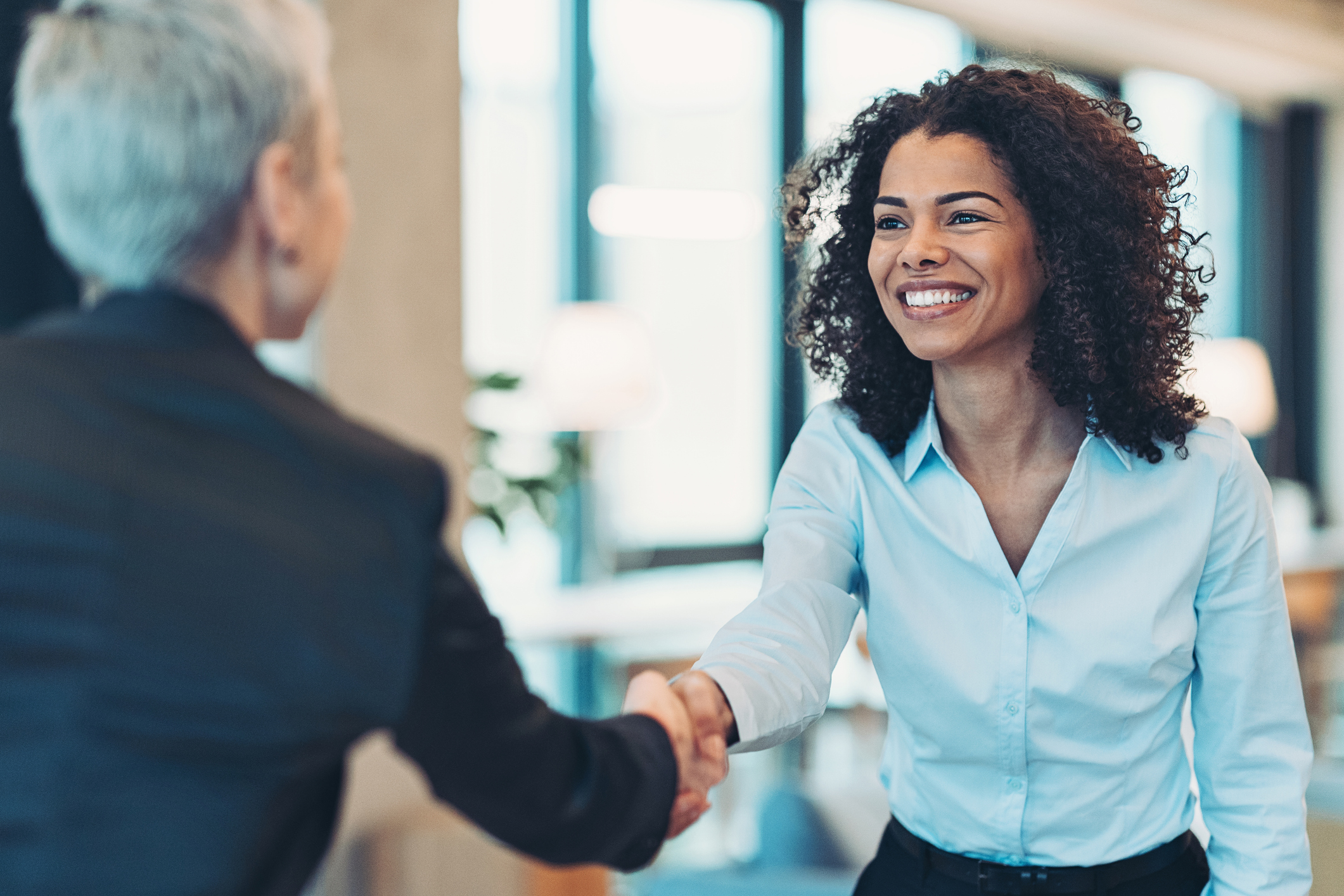 People shaking hands at office in professional setting