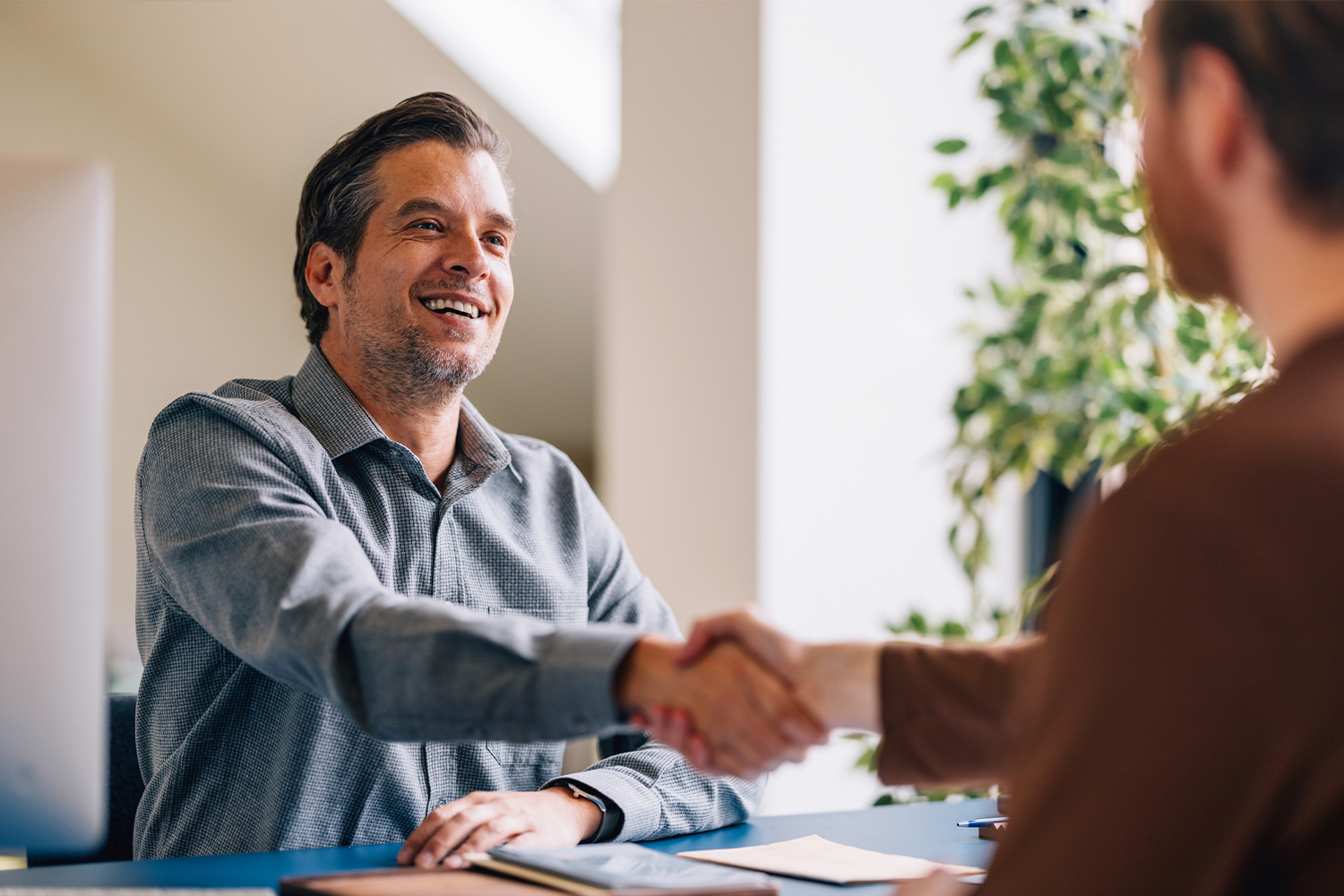 Two men shaking hands after a successful interview.